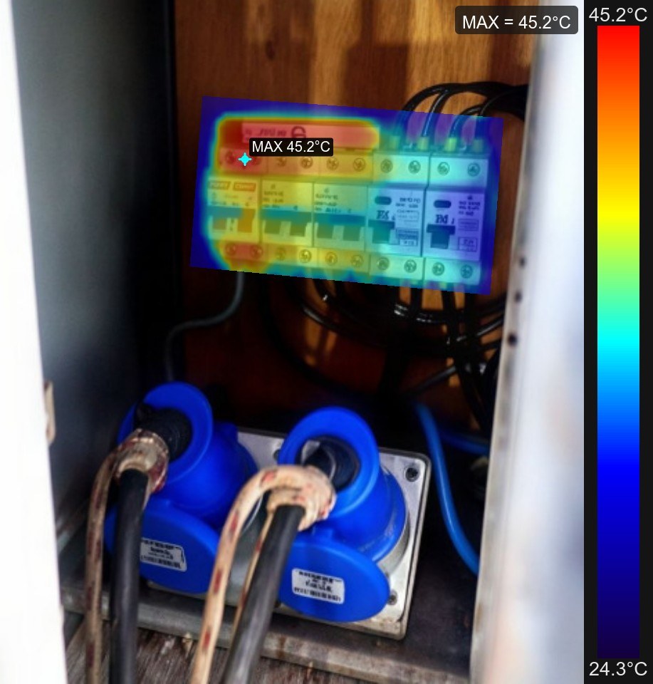 Imagem mesclada sobrepondo a leitura termográfica à foto real do quadro de disjuntores, localizando exatamente o ponto de aquecimento